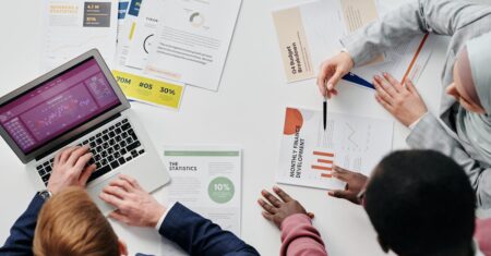 Pessoas discutindo gráficos e relatórios financeiros em uma mesa